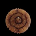 Le Sceau du Dragon 4.8 cm x 5 mm x 25 g Un pendentif puissant et spectaculaire, réunissant dragons protecteurs, équilibre Yin-Yang et Bagua, pour créer un talisman complet : protecteur, harmonisant et chargé de sens. Ce pendentif en jade fumé présente une sculpture et une symbolique exceptionnelles : une boule intérieure mobile, entourée du motif du Bagua et protégée par quatre têtes de dragons soigneusement sculptées. Sa forme circulaire évoque l’harmonie du Yin-Yang, tandis que les trigrammes gravés renforcent son énergie symbolique. Les quatre dragons : en Chine, le dragon est symbole de puissance, de chance, de protection et d’ascension spirituelle. Les quatre directions qu’ils incarnent créent un cercle de protection totale, évoquant les quatre gardiens célestes et la maîtrise des forces du monde. Yin-Yang : équilibre des forces opposées, harmonie intérieure, circulation fluide de l’énergie. Bagua (八卦) : les huit trigrammes représentent les énergies fondamentales de l’univers, favorisant protection, Feng Shui, et équilibre du Qi. Boule captive : symbole d’unité, d’âme préservée et de maîtrise artisanale. • Apporte protection énergétique et chance • Équilibre les émotions et renforce la stabilité intérieure • Favorise la clarté mentale et une circulation harmonieuse du Qi • Procure apaisement grâce au mouvement doux de la boule centrale